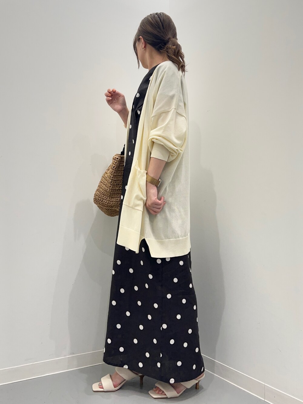 ブラック系のワンピース、ホワイト系のカーディガン/ボレロ、ベージュ系のかごバッグを着用したレディースの夏コーディネートの7枚目の写真