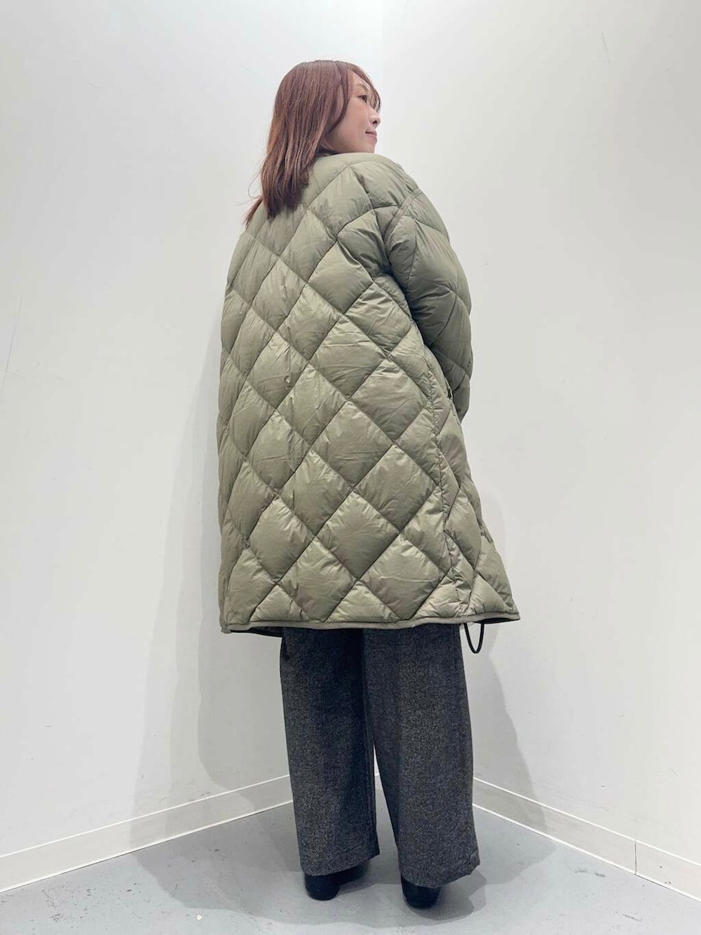 ブラック系のローファー、ホワイト系のショルダーバッグ、グリーン系のダウンジャケット/コートを着用したレディースの秋コーディネートの4枚目の写真