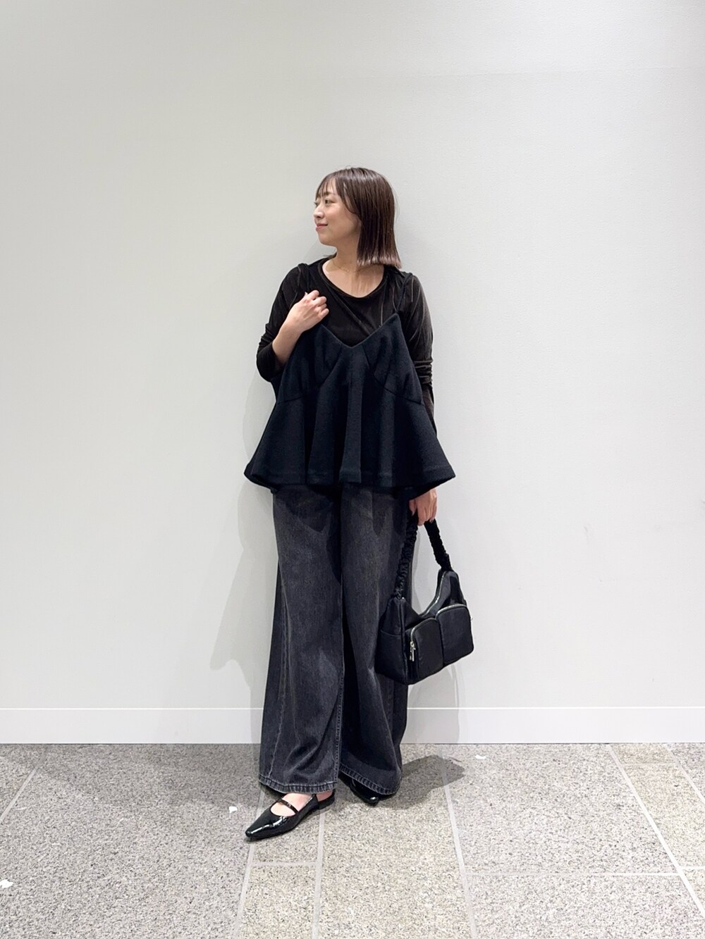 ブラック系のキャミソール、ブラウン系のTシャツ/カットソー、ブラック系のパンプスを着用したレディースの秋コーディネートの2枚目の写真