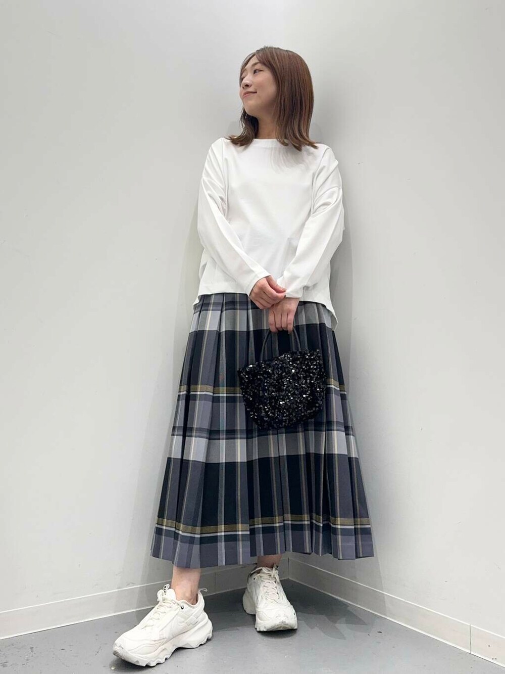 ブラック系のショルダーバッグ、ホワイト系のスニーカー、ホワイト系のTシャツ/カットソーを着用したレディースの秋コーディネートの2枚目の写真
