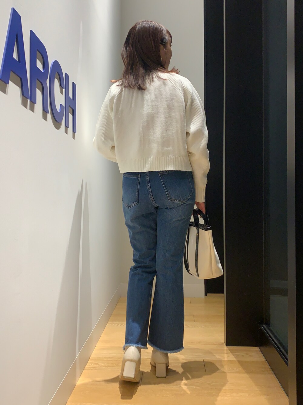 ホワイト系のカーディガン/ボレロ、ブルー系のデニムパンツ、ホワイト系のブーツを着用したレディースの冬コーディネートの2枚目の写真