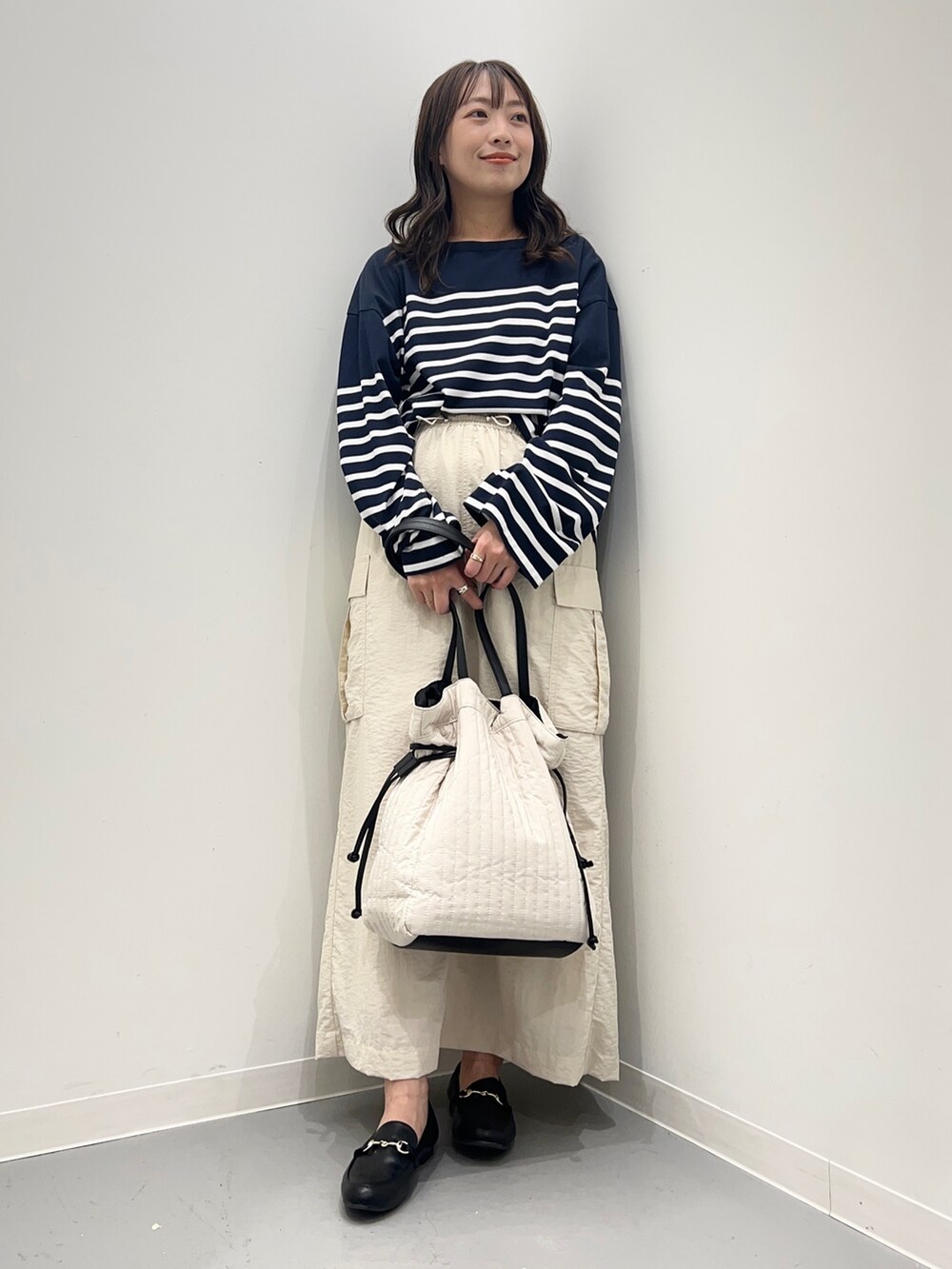 ホワイト系のスカート、ブルー系のTシャツ/カットソー、ブラック系のローファーを着用したレディースの夏コーディネートの4枚目の写真