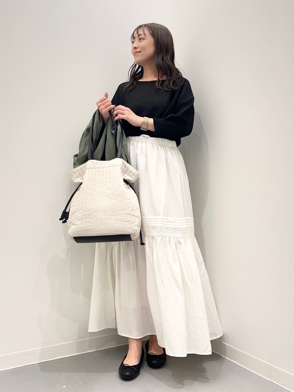 グリーン系のジャケット/アウター、ブラック系のニット/セーター、ホワイト系のスカートを着用したレディースの夏コーディネートの8枚目の写真