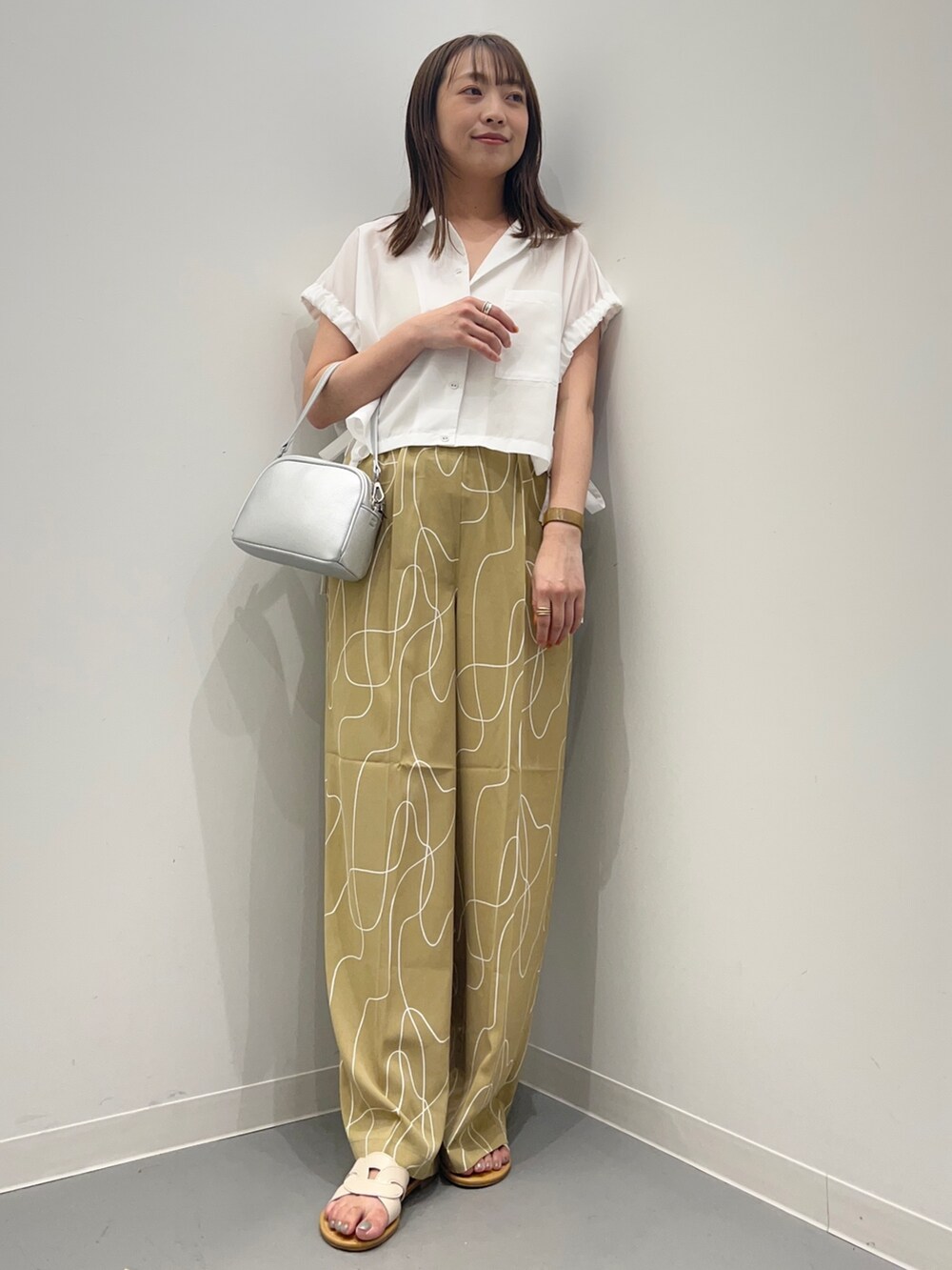ホワイト系のシャツ/ブラウス、ベージュ系のその他パンツ、ホワイト系のサンダルを着用したレディースの夏コーディネートの6枚目の写真