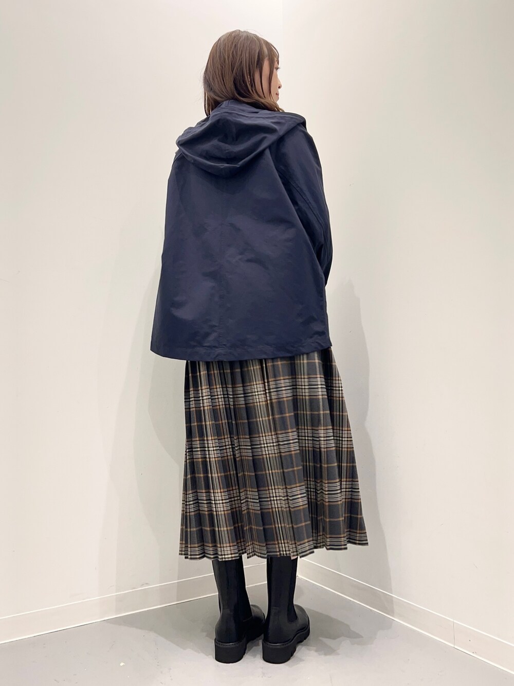 ホワイト系のTシャツ/カットソー、グレー系のスカート、ブルー系のダウンベストを着用したレディースの秋コーディネートの7枚目の写真