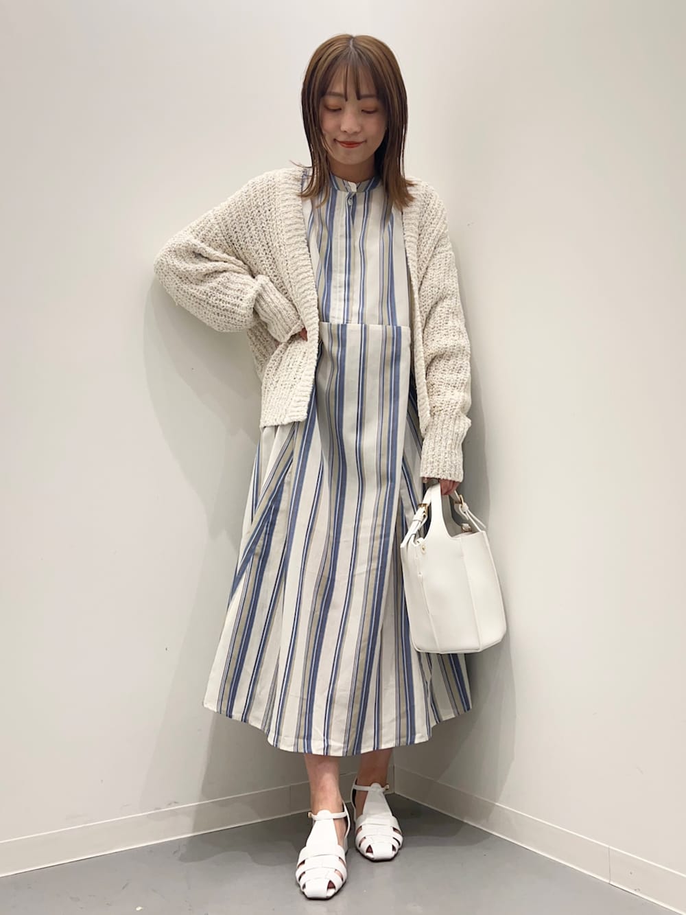 ホワイト系のカーディガン/ボレロ、ホワイト系のサンダル、ブルー系のワンピースを着用したレディースの春コーディネートの3枚目の写真