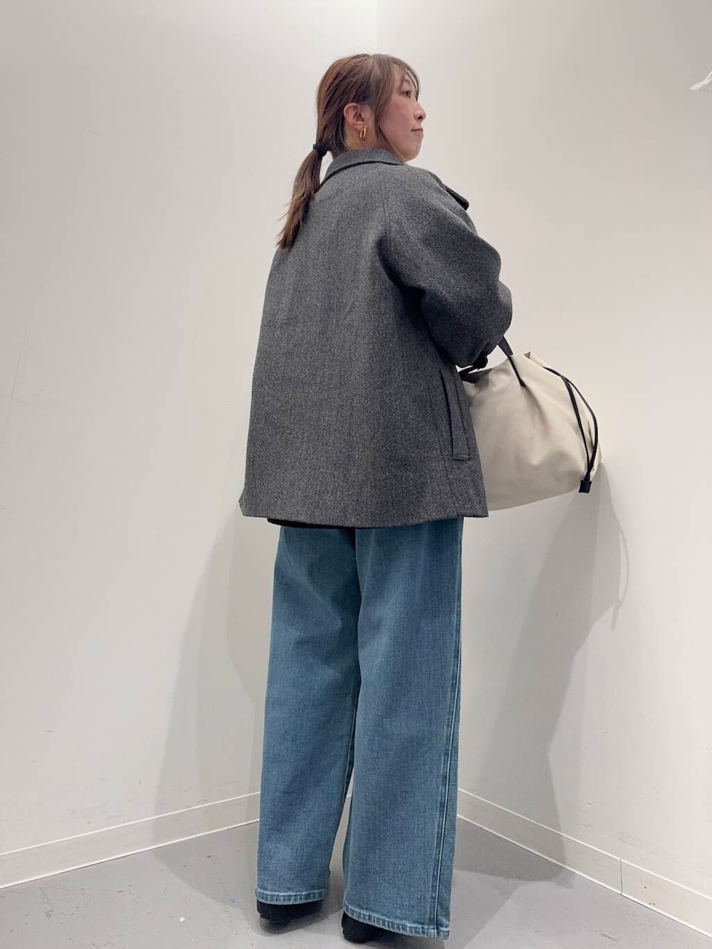 ブラック系のローファー、ホワイト系のショルダーバッグ、グレー系のトレンチコートを着用したレディースの冬コーディネートの3枚目の写真