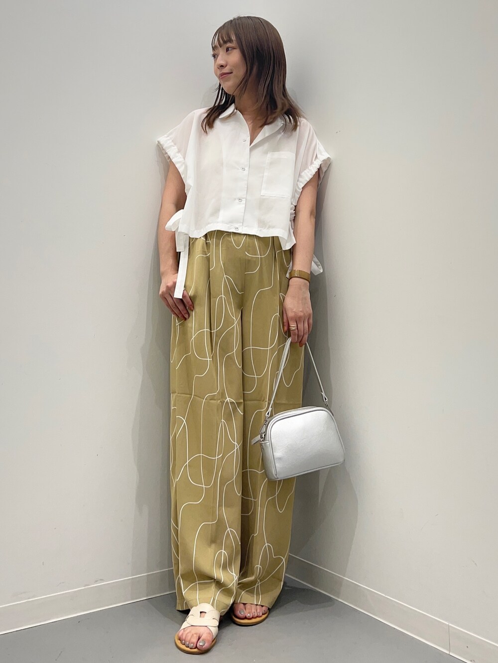 ホワイト系のシャツ/ブラウス、ベージュ系のその他パンツ、ホワイト系のサンダルを着用したレディースの夏コーディネートの3枚目の写真