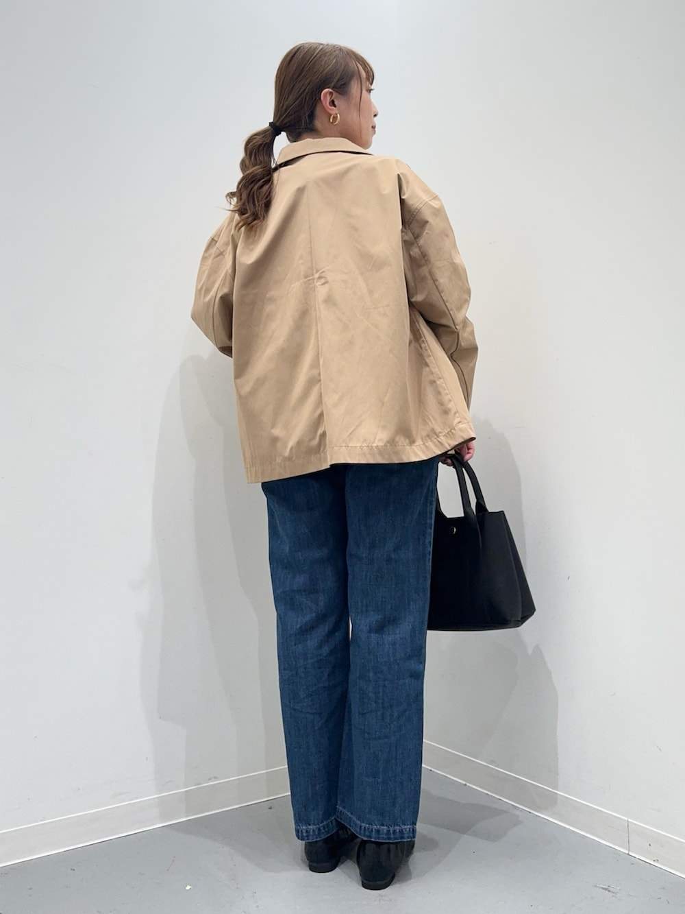 ホワイト系のニット/セーター、ベージュ系のその他アウター、ブルー系のデニムパンツを着用したレディースの春コーディネートの4枚目の写真