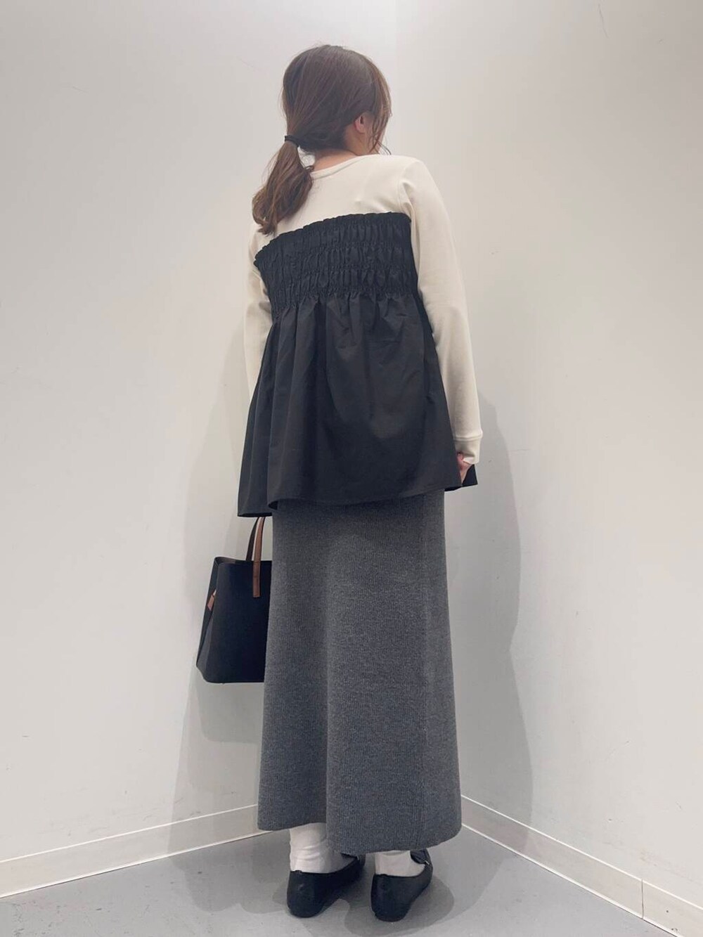 ブラック系のローファー、ブラック系のトートバッグ、ホワイト系のTシャツ/カットソーを着用したレディースの冬コーディネートの4枚目の写真