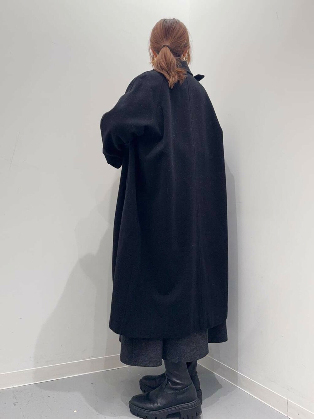 ブラック系のトートバッグ、ブラック系のブーツ、レッド系のニット/セーターを着用したレディースの冬コーディネートの2枚目の写真