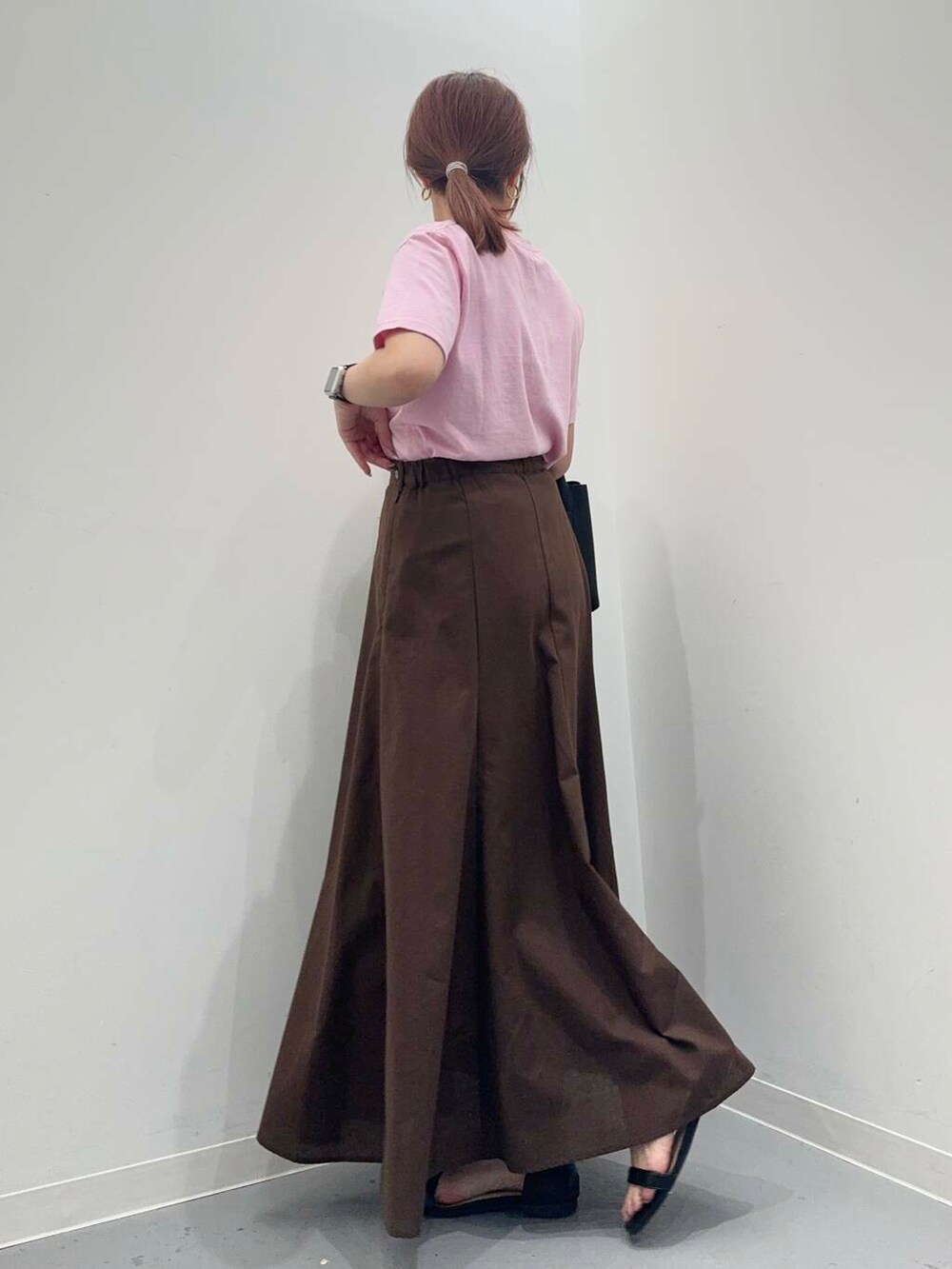 ブラック系のトートバッグ、ブラック系のサンダル、ブラウン系のスカートを着用したレディースの夏コーディネートの3枚目の写真