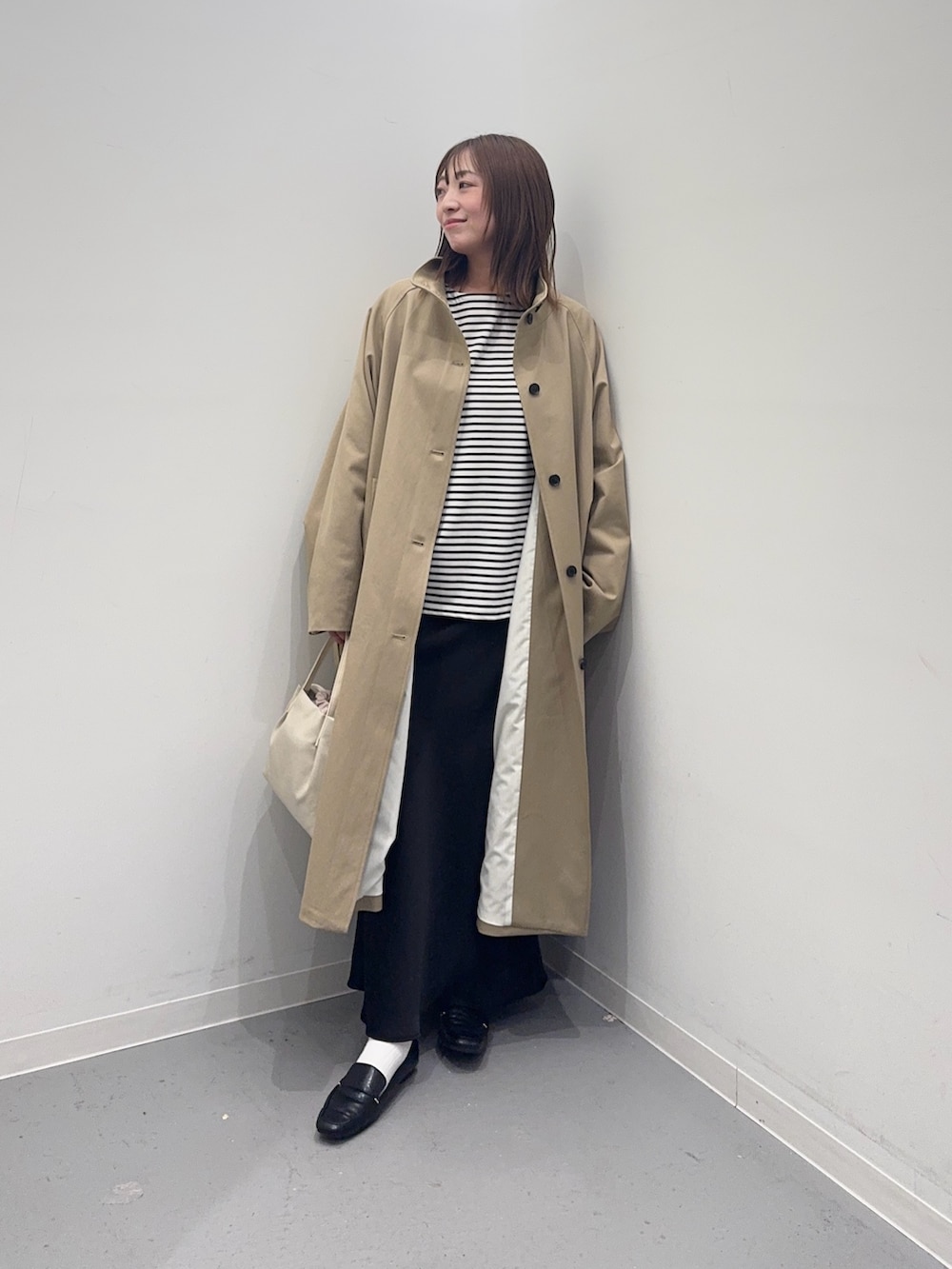 ベージュ系のその他アウター、ホワイト系のTシャツ/カットソー、ブラック系のスカートを着用したレディースの春コーディネートの3枚目の写真
