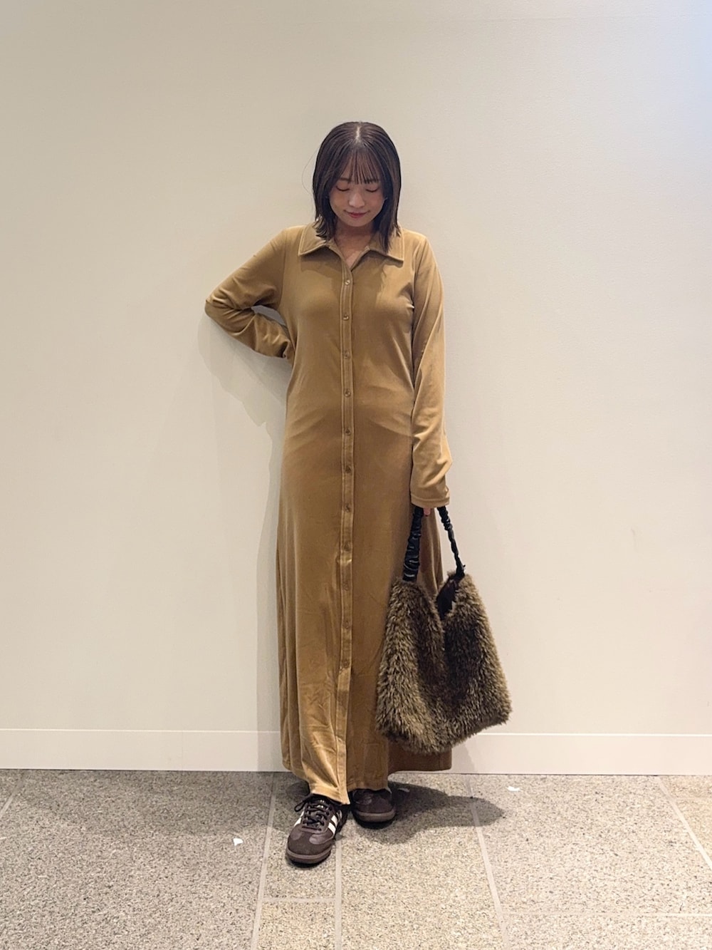 ベージュ系のワンピース、ブラウン系のスニーカー、ブラウン系のトートバッグを着用したレディースの秋コーディネートの2枚目の写真