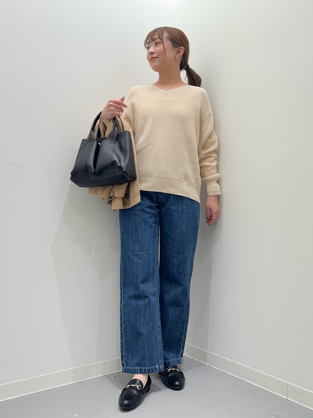 ホワイト系のニット/セーター、ベージュ系のその他アウター、ブルー系のデニムパンツを着用したレディースの春コーディネートの6枚目の写真