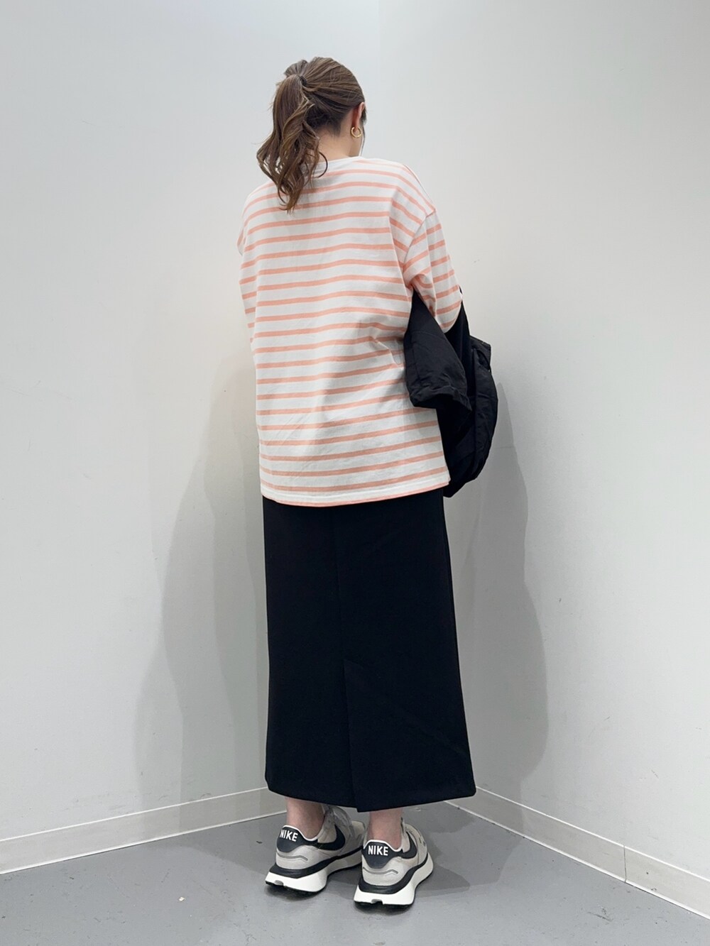 ピンク系のTシャツ/カットソー、ブラック系のマウンテンパーカー、ブラック系のスカートを着用したレディースの春コーディネートの8枚目の写真