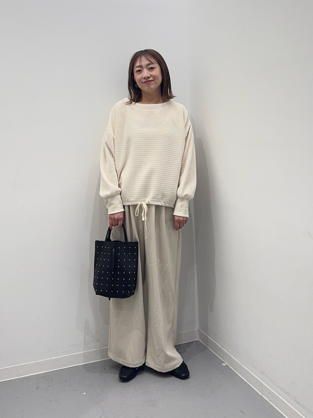 ホワイト系のTシャツ/カットソー、ホワイト系のその他パンツ、ブラック系のトートバッグを着用したレディースの冬コーディネートの2枚目の写真