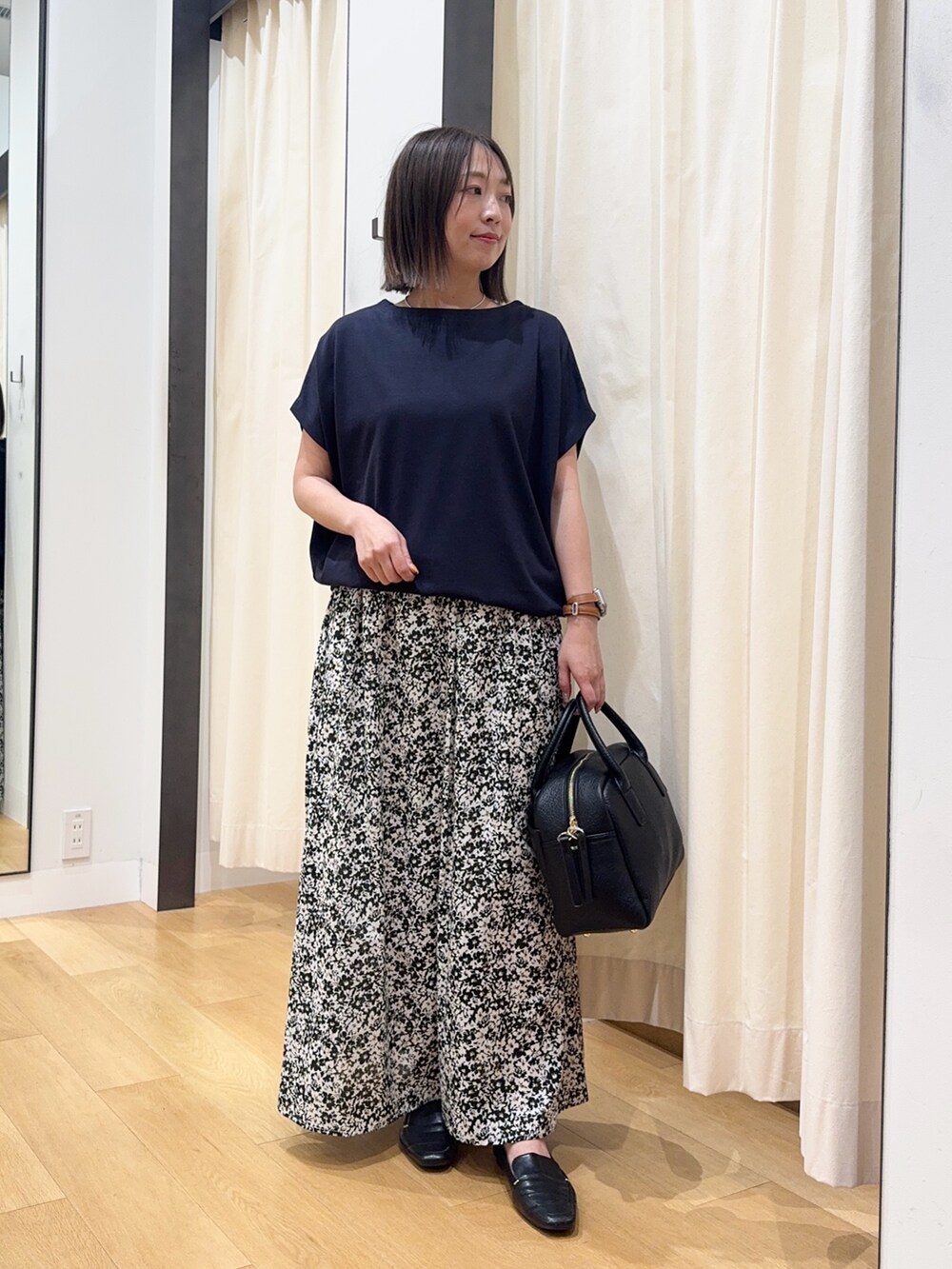 ブルー系のTシャツ/カットソー、ブラック系のスカート、ブラック系のボストンバッグを着用したレディースの夏コーディネートの2枚目の写真