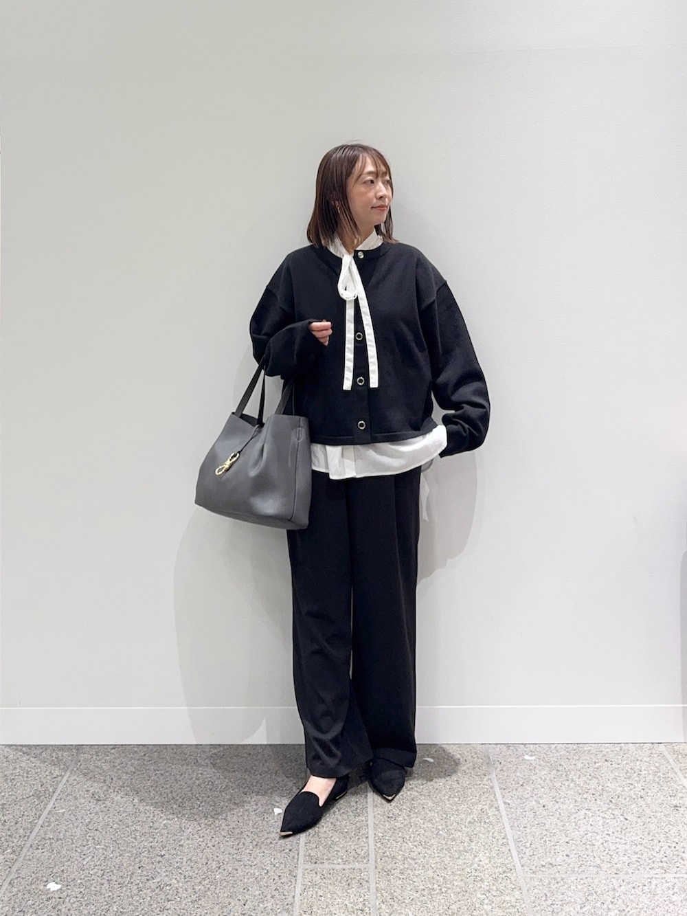 ブラック系のカーディガン/ボレロ、ホワイト系のシャツ/ブラウス、ブラック系のその他パンツを着用したレディースの秋コーディネートの4枚目の写真
