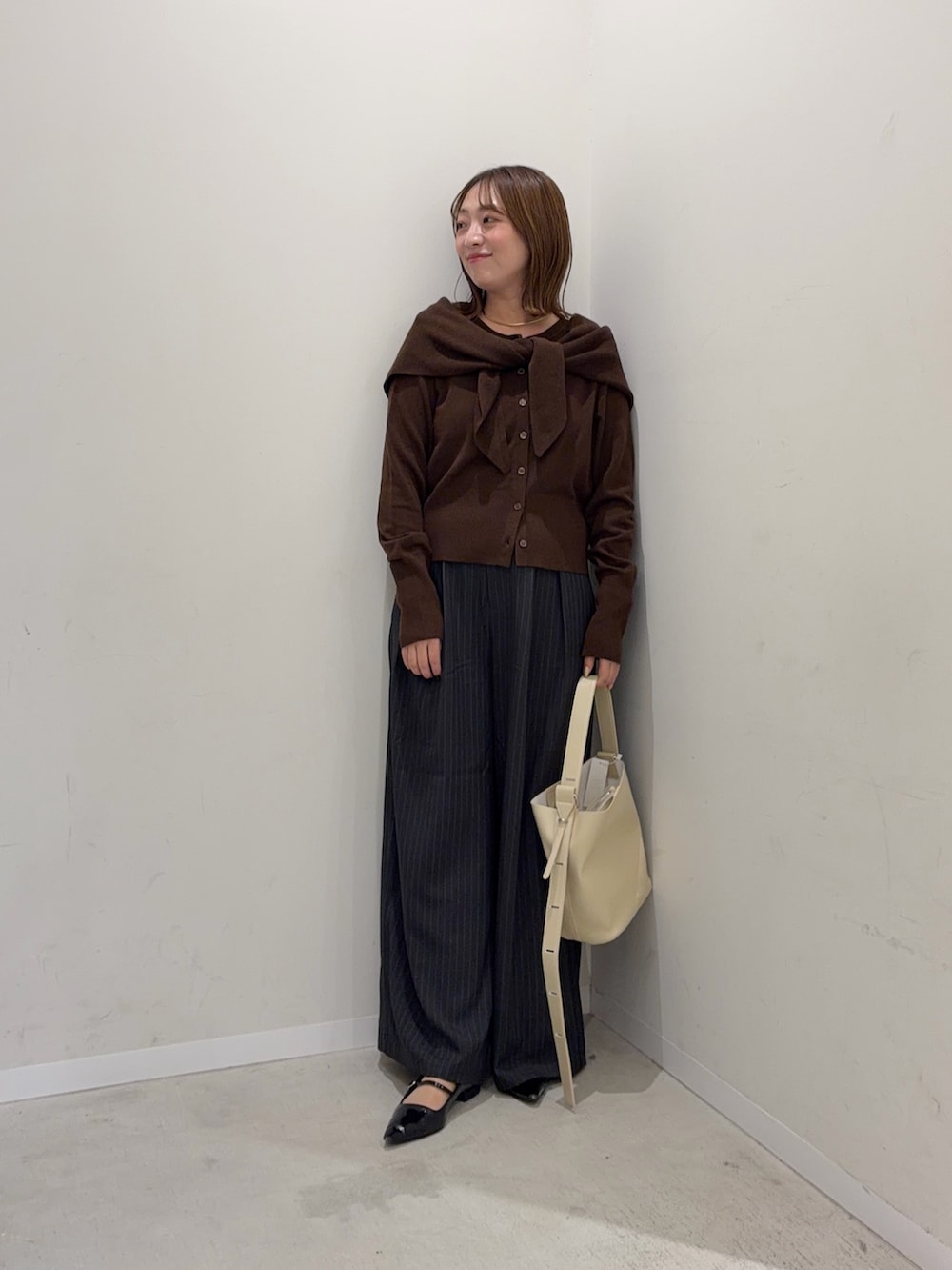ブラウン系のカーディガン/ボレロ、グレー系のその他パンツ、ベージュ系のショルダーバッグを着用したレディースの秋コーディネートの2枚目の写真