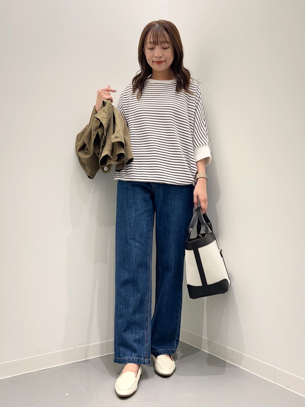 ブルー系のデニムパンツ、グリーン系のその他アウター、ホワイト系のTシャツ/カットソーを着用したレディースの秋コーディネートの8枚目の写真