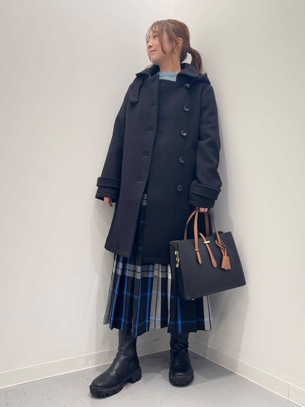 ブラック系のトートバッグ、ブラック系のその他アウター、ブラック系のブーツを着用したレディースの冬コーディネートの5枚目の写真