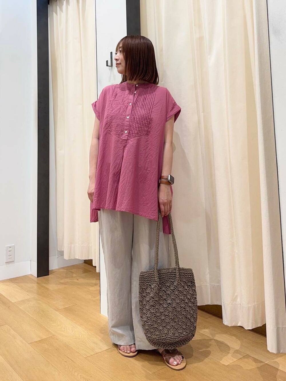 ブラウン系のサンダル、グレー系のトートバッグ、ピンク系のTシャツ/カットソーを着用したレディースの夏コーディネートの2枚目の写真