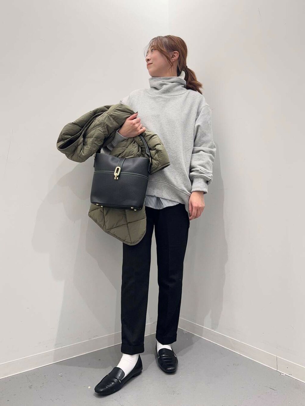 ブラック系のローファー、グリーン系のダウンジャケット/コート、ブルー系のシャツ/ブラウスを着用したレディースの冬コーディネートの6枚目の写真