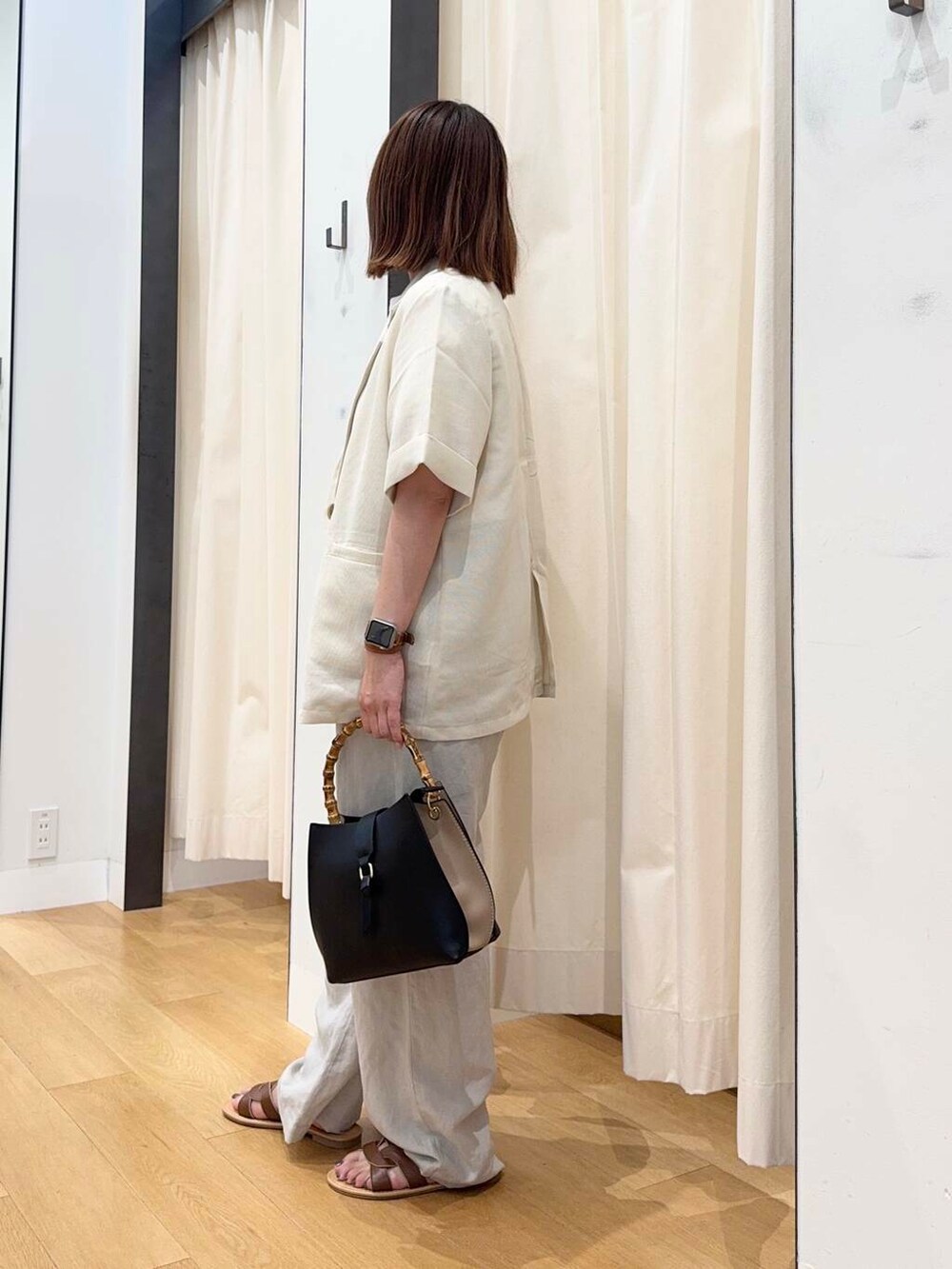 ブラウン系のサンダル、ベージュ系のその他パンツ、ブラック系のハンドバッグを着用したレディースの夏コーディネートの3枚目の写真