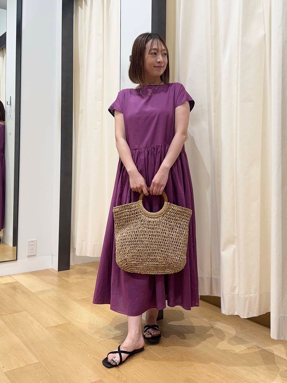 ベージュ系のトートバッグ、グレー系のワンピース、ブラック系のサンダルを着用したレディースの夏コーディネートの5枚目の写真