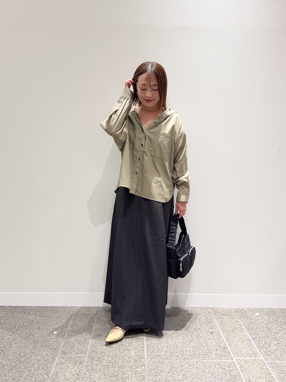 ベージュ系のシャツ/ブラウス、グレー系のスカート、ベージュ系のパンプスを着用したレディースの秋コーディネートの4枚目の写真