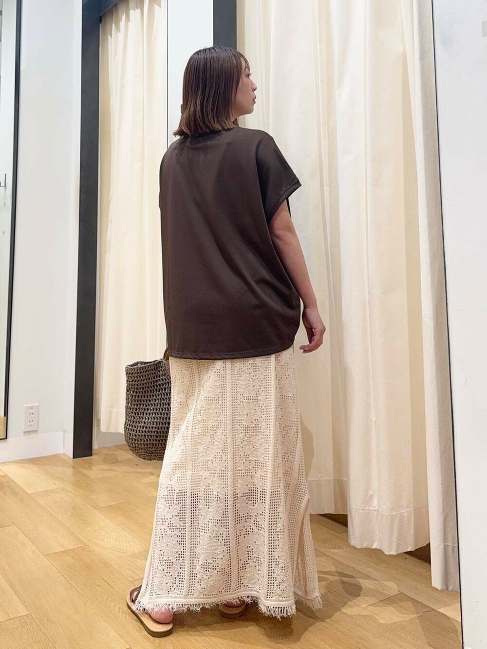 ブラウン系のサンダル、グレー系のトートバッグ、ホワイト系のスカートを着用したレディースの夏コーディネートの4枚目の写真