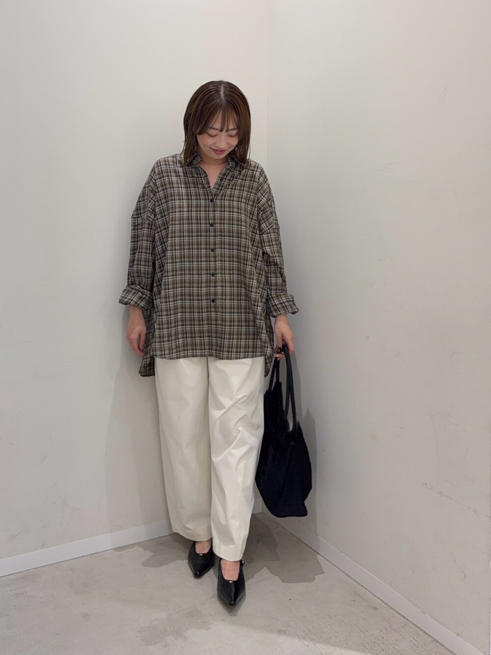 ブラウン系のシャツ/ブラウス、ホワイト系のその他パンツ、ブラック系のトートバッグを着用したレディースの秋コーディネートの4枚目の写真