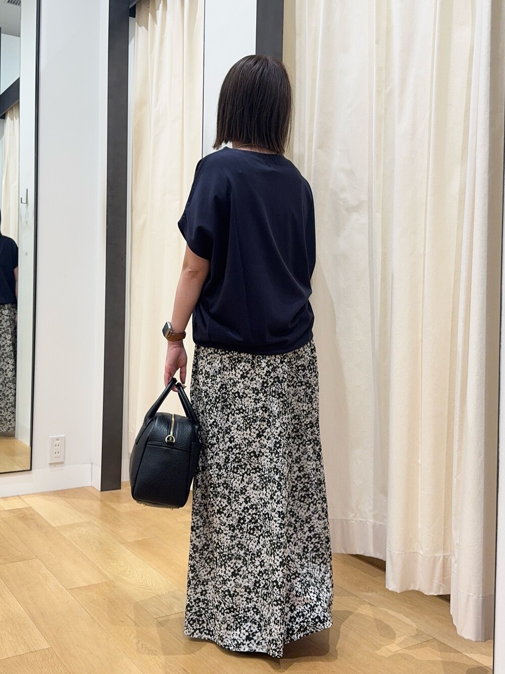 ブルー系のTシャツ/カットソー、ブラック系のスカート、ブラック系のボストンバッグを着用したレディースの夏コーディネートの4枚目の写真