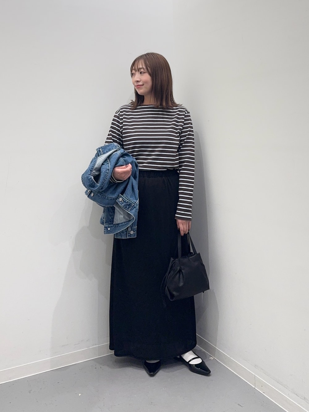 ブルー系のデニムジャケット、ブルー系のTシャツ/カットソー、ブラック系のスカートを着用したレディースの冬コーディネートの5枚目の写真