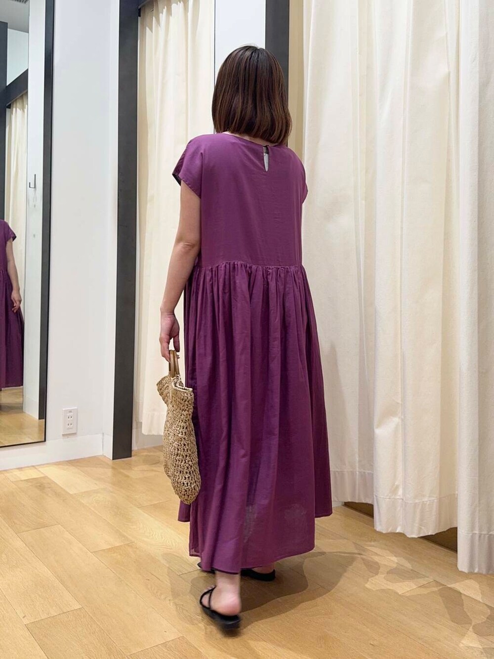 ベージュ系のトートバッグ、グレー系のワンピース、ブラック系のサンダルを着用したレディースの夏コーディネートの3枚目の写真