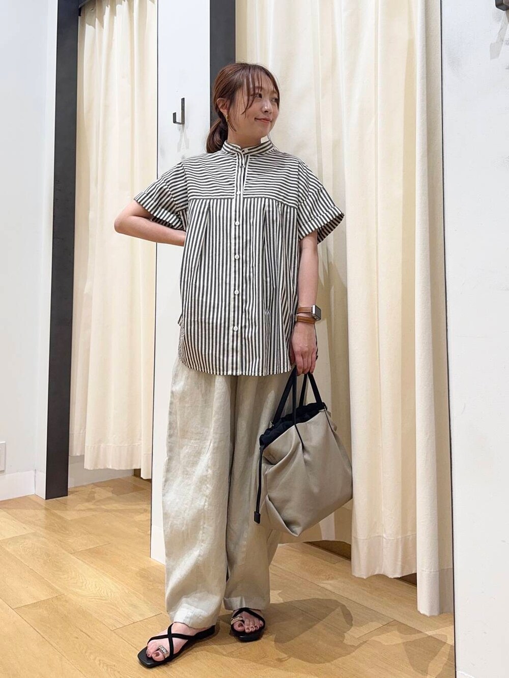 ベージュ系のショルダーバッグ、ブラック系のシャツ/ブラウス、ブラック系のサンダルを着用したレディースの夏コーディネートの5枚目の写真