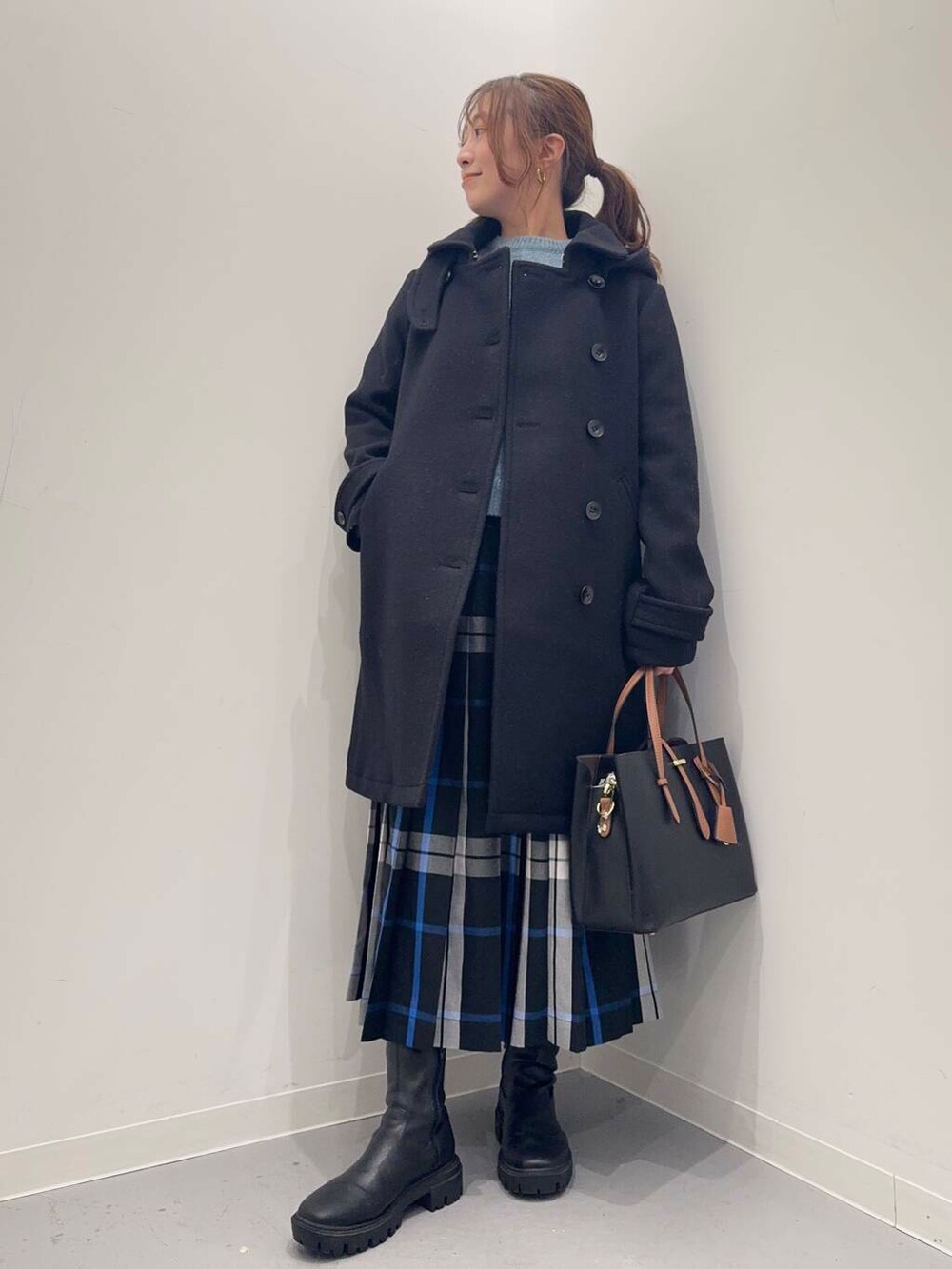 ブラック系のトートバッグ、ブラック系のその他アウター、ブラック系のブーツを着用したレディースの冬コーディネートの9枚目の写真