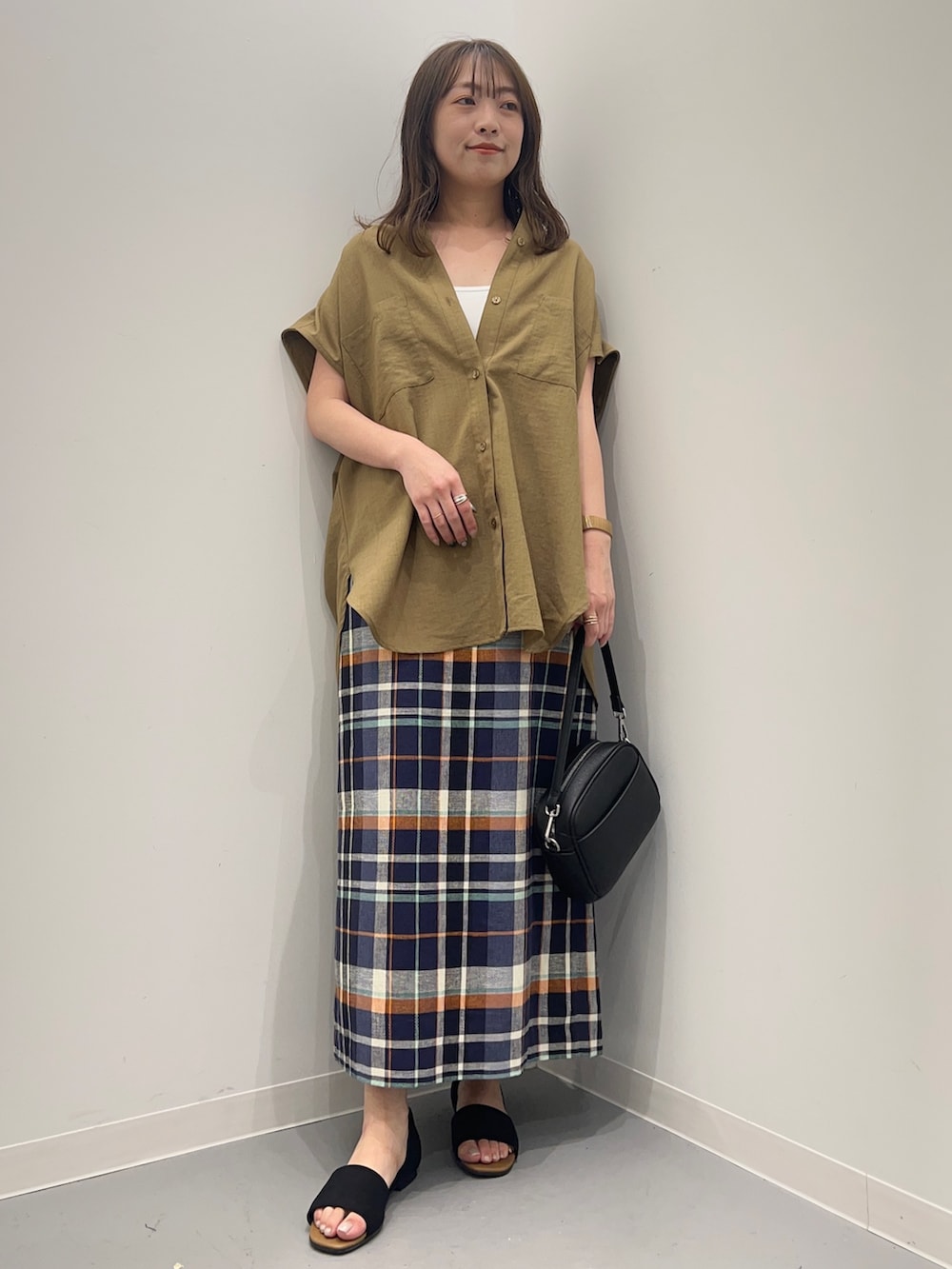 ベージュ系のシャツ/ブラウス、ブルー系のスカート、ブラック系のサンダルを着用したレディースの夏コーディネートの2枚目の写真