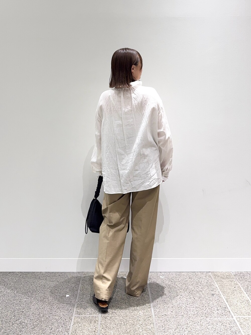 ホワイト系のシャツ/ブラウス、ベージュ系のその他パンツ、ブラック系のショルダーバッグを着用したレディースの秋コーディネートの3枚目の写真