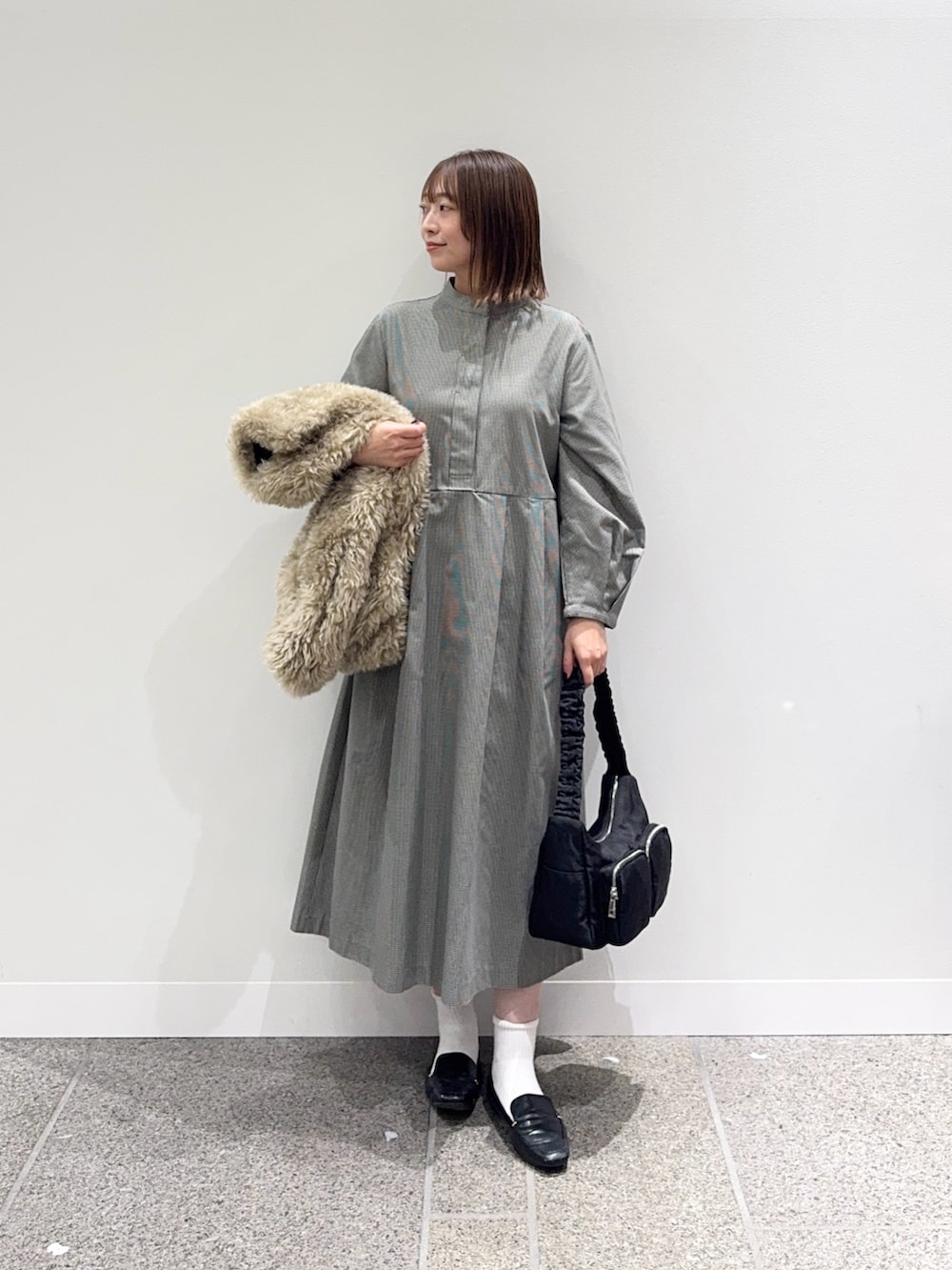 グレー系のワンピース、ベージュ系のその他アウター、ブラック系のショルダーバッグを着用したレディースの秋コーディネートの4枚目の写真