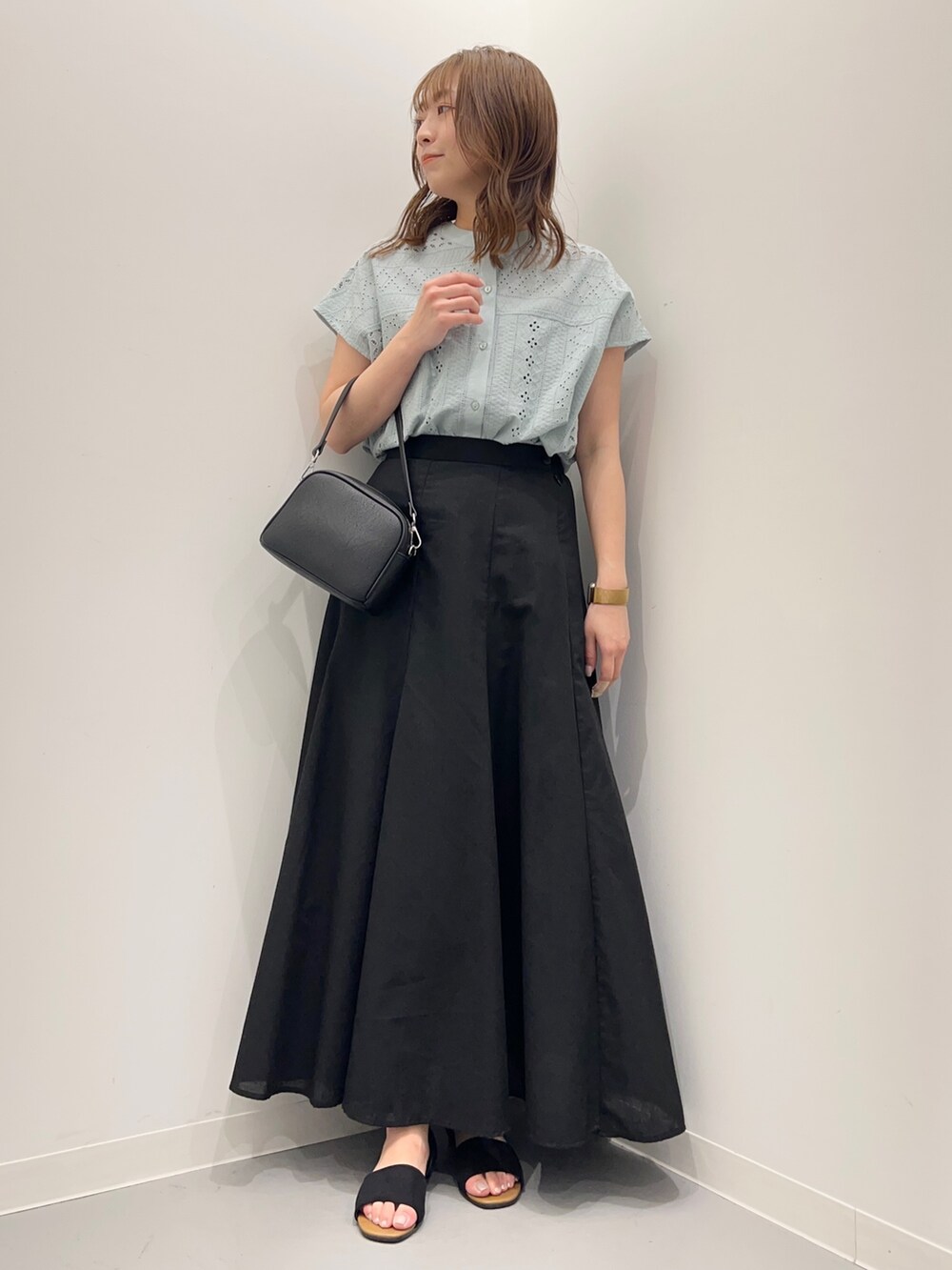 グリーン系のシャツ/ブラウス、ブラック系のスカート、ブラック系のショルダーバッグを着用したレディースの春コーディネートの2枚目の写真