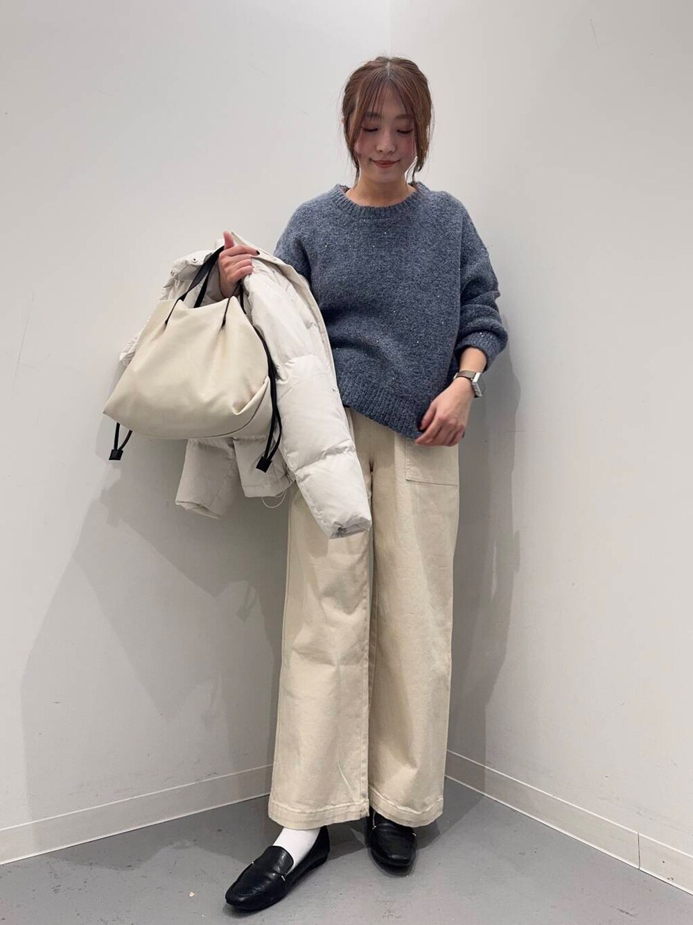 ブラック系のローファー、ホワイト系のショルダーバッグ、ホワイト系のダウンジャケット/コートを着用したレディースの冬コーディネートの4枚目の写真