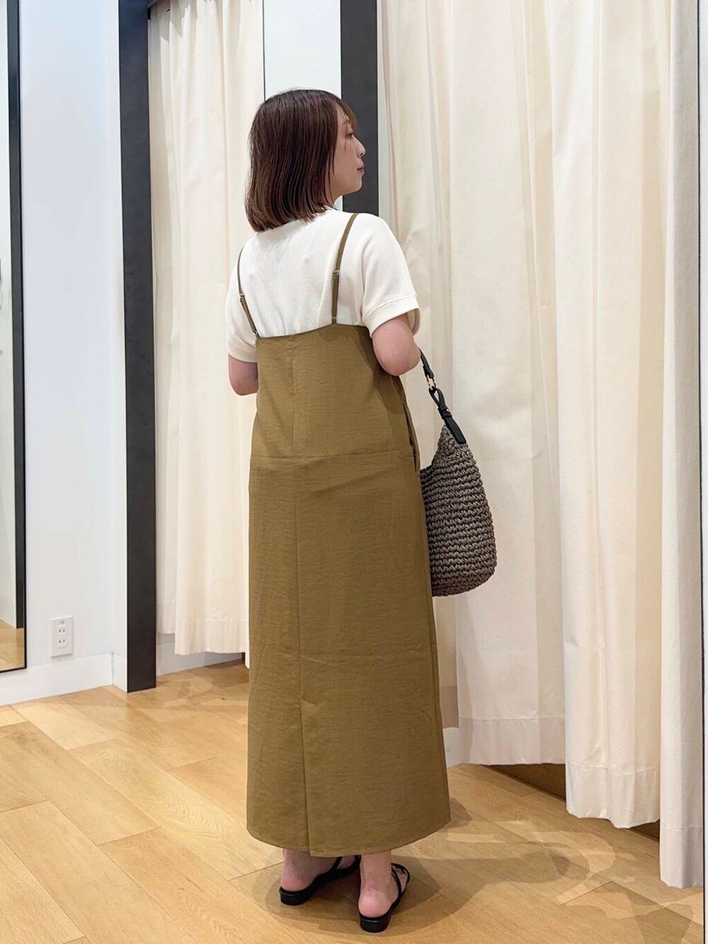 グレー系のトートバッグ、ベージュ系のTシャツ/カットソー、ブラック系のサンダルを着用したレディースの夏コーディネートの4枚目の写真