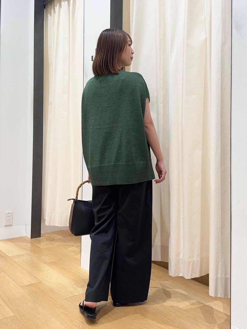 ブラック系のトートバッグ、ブラック系のバレエシューズ、ホワイト系のその他パンツを着用したレディースの夏コーディネートの3枚目の写真