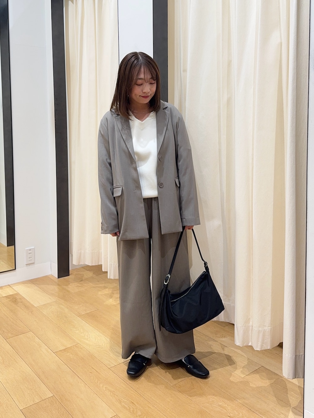 グレー系のその他アウター、ホワイト系のニット/セーター、グレー系のその他パンツを着用したレディースの冬コーディネートの3枚目の写真