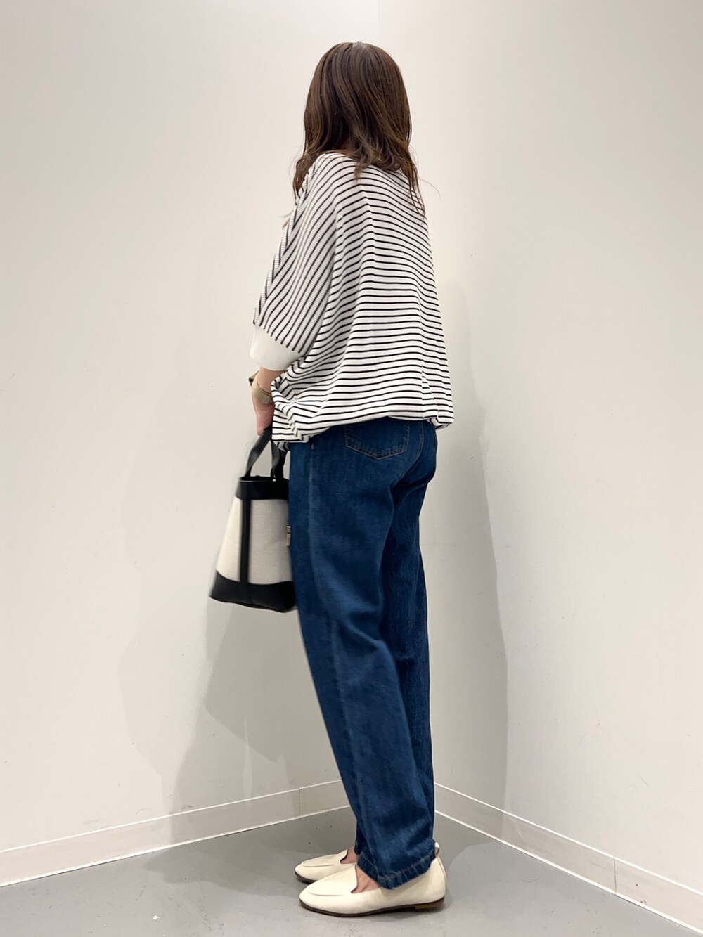 ブルー系のデニムパンツ、グリーン系のその他アウター、ホワイト系のTシャツ/カットソーを着用したレディースの秋コーディネートの9枚目の写真