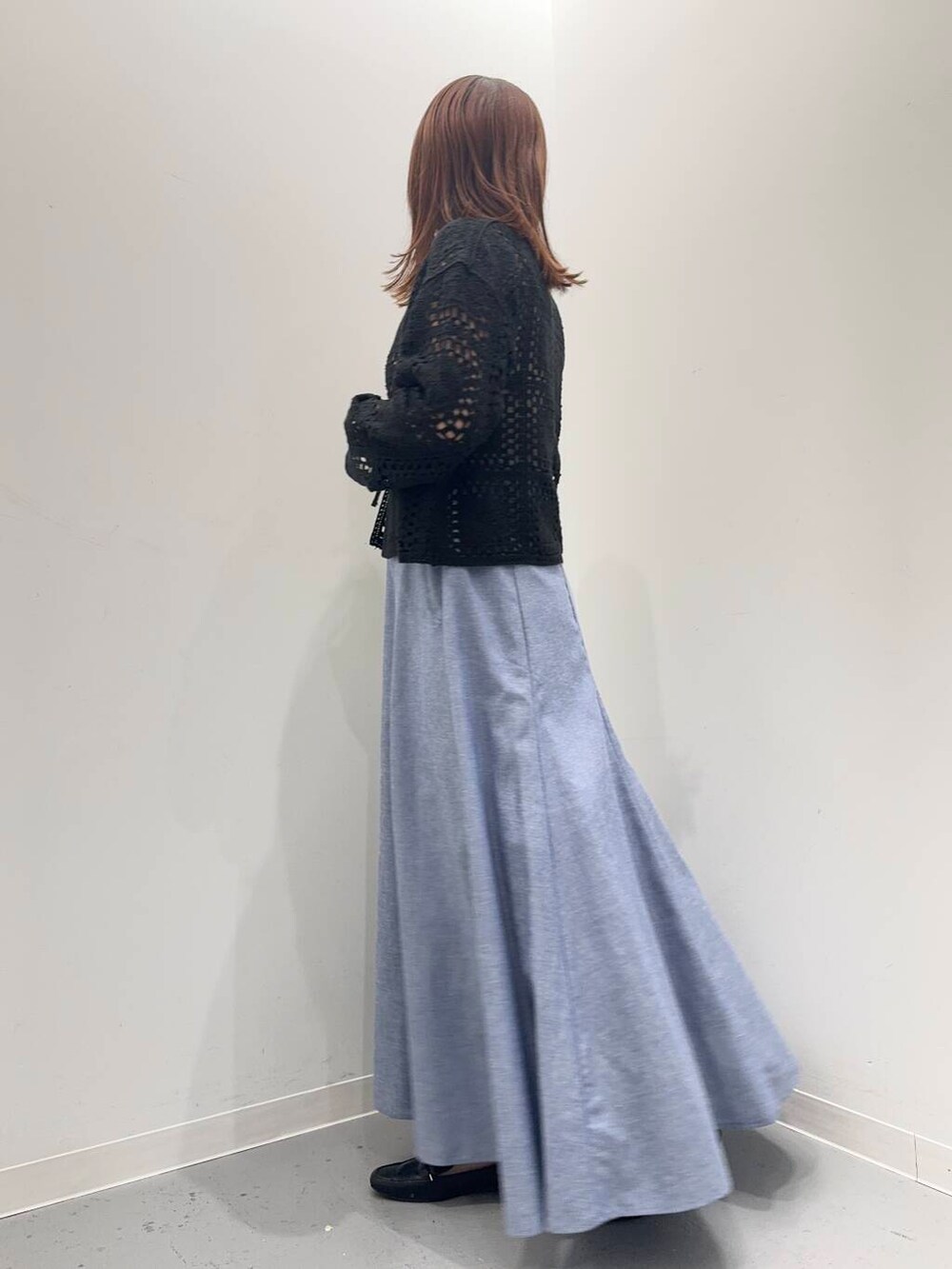 ブラック系のローファー、ブラック系のトートバッグ、ブルー系のスカートを着用したレディースの夏コーディネートの3枚目の写真