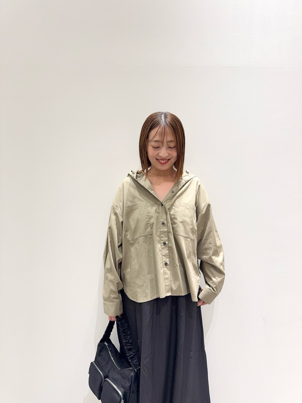 ベージュ系のシャツ/ブラウス、グレー系のスカート、ベージュ系のパンプスを着用したレディースの秋コーディネートの7枚目の写真