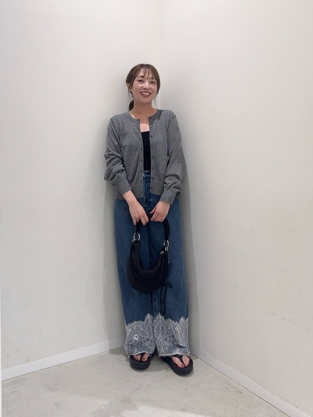 グレー系のカーディガン/ボレロ、ブルー系のデニムパンツ、ブラック系のハンドバッグを着用したレディースの夏コーディネートの4枚目の写真
